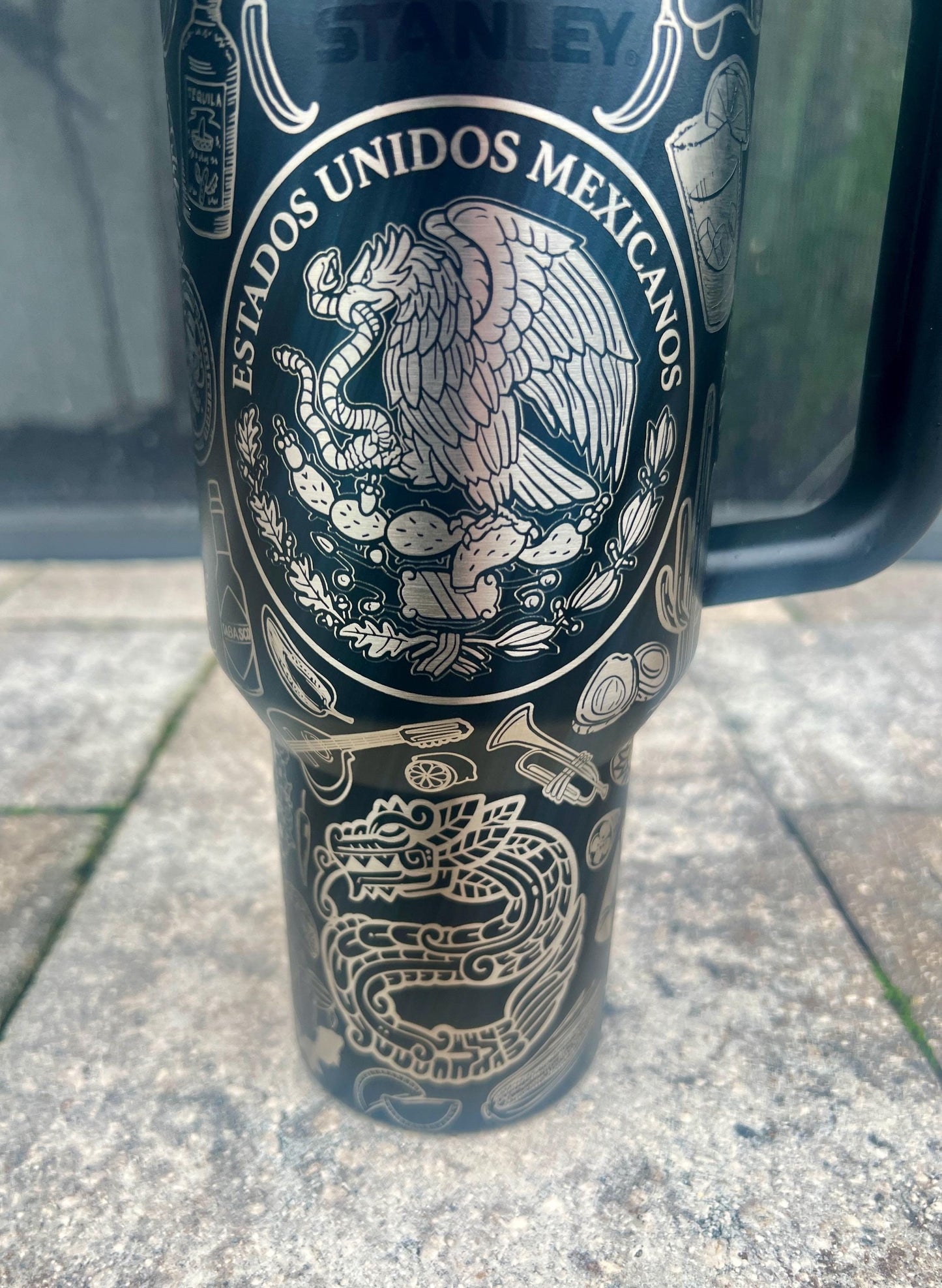 Close-up of eagle and serpent engraving from a Mexican heritage wrap on a Black Stanley 40oz Quencher H2.0 personalized tumbler.